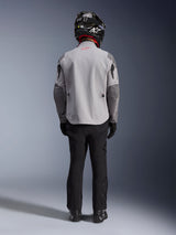 Alpinestars Maxdura Drystar®XF Laminated Armored Shell, motorcycle jacket in Mid Gray and Dark Gray, seen from the back on a rider, worn with black pants, black boots, and a black and white helmet, adventure touring gear