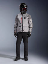 Alpinestars Maxdura Drystar®XF Laminated Armored Shell, Mid Gray and Dark Gray adventure jacket with red zipper accents, worn by a rider with a black helmet, red goggles, and black pants, professional all-weather motorcycle gear