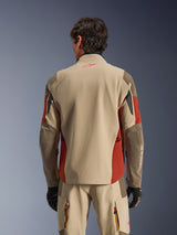 Man draagt de Alpinestars Maxdura Drystar®XF Laminated Armored Shell van achteren gezien, adventure-jas in Aluminum Walnut en Rust Brown, bijpassende technische broek en zwarte handschoenen, 3-laags gelamineerde textielconstructie met verstevigde panelen, gecoördineerde outfit voor motortouring