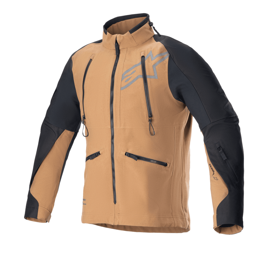 Alpinestars Hyde XT Drystar XF Jacket, adventure touring motorjas, zandkleurig en zwart, met verticale ventilatieritsen op de borst en zijzakken, zwarte ripstop-panelen op de schouders en armen, hoge kraag, waterdichte textielconstructie voor off-road rijden