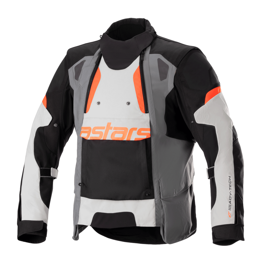 Alpinestars Halo Drystar motorjas, adventure touring motorjas, donkergrijs, ijsgrijs en zwart met oranje accenten, voorzien van een asymmetrisch ventilatiepaneel aan de voorzijde, oranje astars-logo, verstelbare mouwbanden en een hoge kraag, beschermende textielkleding voor adventure-rijden in alle seizoenen