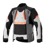 Alpinestars Halo Drystar motorjas, adventure touring motorjas, donkergrijs, ijsgrijs en zwart met oranje accenten, voorzien van een asymmetrisch ventilatiepaneel aan de voorzijde, oranje astars-logo, verstelbare mouwbanden en een hoge kraag, beschermende textielkleding voor adventure-rijden in alle seizoenen