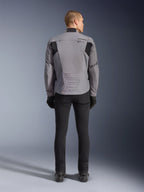 Alpinestars SMX Waterproof Jacket, achteraanzicht, donkergrijs en zwart, voorzien van zwarte textielpanelen op de schouders en een sportieve pasvorm, gecombineerd met een zwarte broek en handschoenen voor een complete motorlook