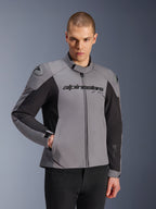 Alpinestars SMX Waterproof Jas, donkergrijs en zwart, gedragen door een mannelijk model, voorzien van 'alpinestars' logo op de borst, DFS Lite schouderbescherming, strak sportief design met textiel en softshell materialen voor rijden op de weg.