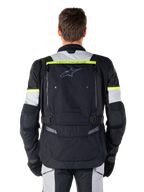 Alpinestars Bogota' Pro Drystar® Jas, Adventure Touring motorjas, Black Ice Gray en Yellow Fluo, achteraanzicht met 'TECH TOURING' branding op een fluorescerende gele streep, groot ventilatiepaneel op de rug en verstelbare taillebanden, technische all-season uitrusting