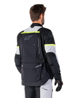 Alpinestars Bogotá Pro Drystar® Jas, adventure touring jas, Black Ice Gray en Yellow Fluo, achteraanzicht met groot achterzakpaneel met 'TECH TOURING'-branding, Alpinestars-logo en fluorescerende accenten, technische textiele motorkleding