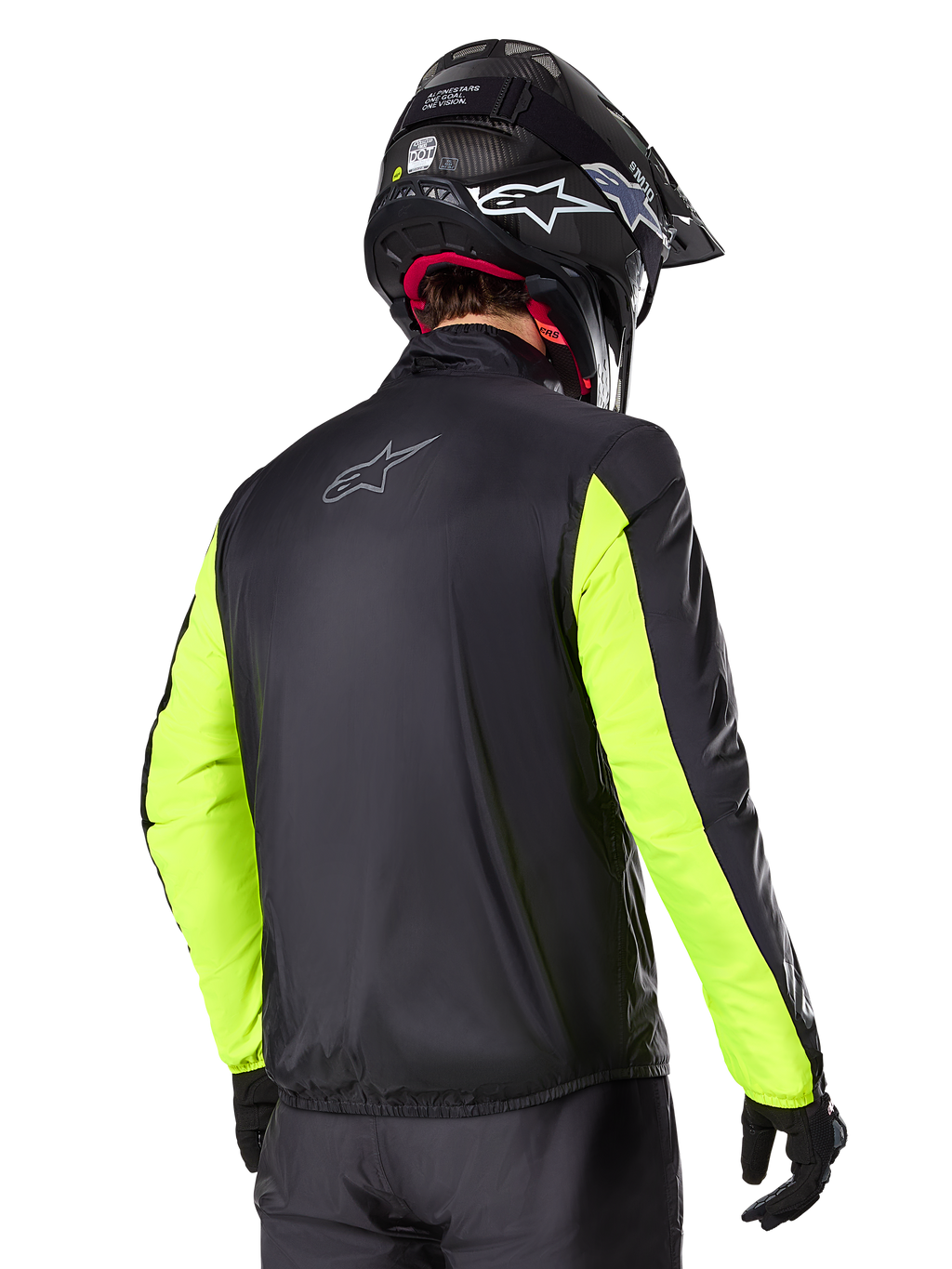 Alpinestars Bogotá Pro Drystar® Jas, achteraanzicht, zwart met Yellow Fluo mouwen, gedragen door een rijder met zwarte helm en handschoenen, high-visibility adventure touring motoruitrusting met een technische textielafwerking.