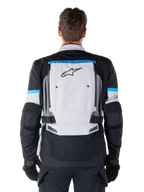 Alpinestars Bogota' Pro Drystar® Jas, adventure motorjas, Ice Gray Black en Cyan, achteraanzicht met een groot lichtgrijs paneel met zwart sterlogo, cyaan accenten met Tech Touring-branding en verstelbare taillebanden