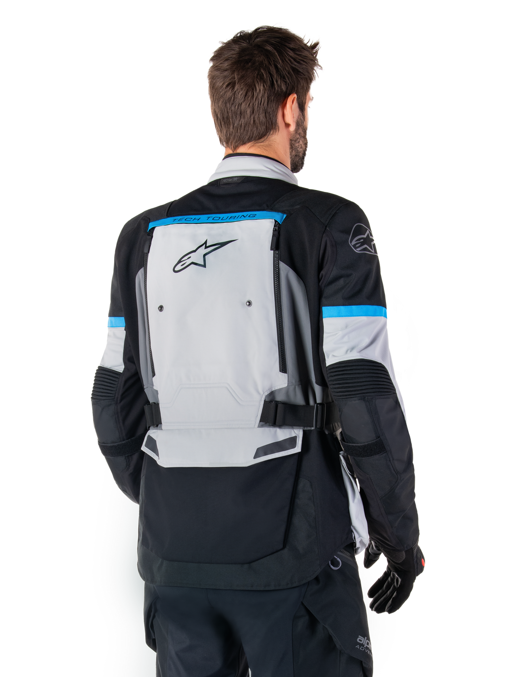 Alpinestars Bogota' Pro Drystar® Jas, adventure motorjas, ijsgrijs, zwart en cyaan, achteraanzicht met focus op het grote grijze rugpaneel met Tech Touring-branding, cyaan accenten op de mouwen en duurzame textielconstructie.