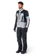 Mannelijke motorrijder die de Alpinestars Bogotá Pro Drystar® Jas draagt in Ice Gray, zwart en cyaan, gecombineerd met een zwarte technische motorbroek en handschoenen, adventure touring-uitrusting voor prestaties onder alle weersomstandigheden.
