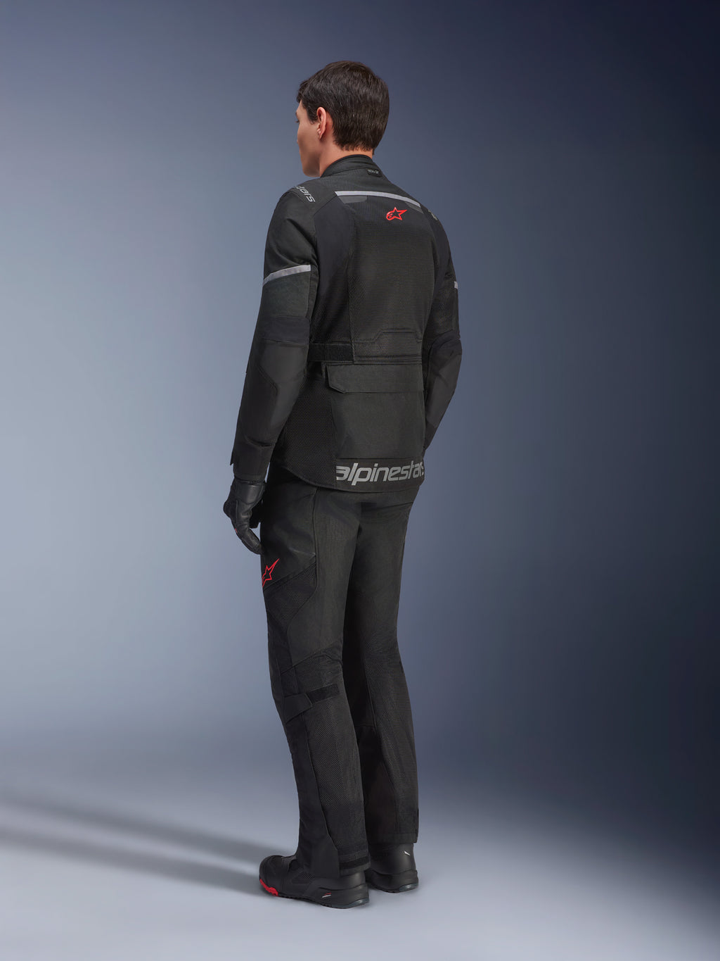 Alpinestars Andes Air Drystar® broek en bijpassende jas, zwart met rode sterlogo's, adventure touring motorkleding van achteren gezien, met mesh-ventilatiepanelen en reflecterende details