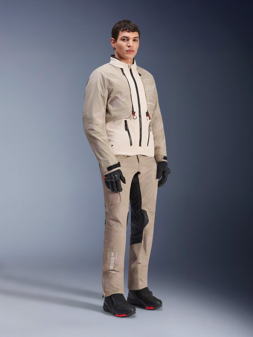 Alpinestars AMT-10LAB Drystar® XF broek en bijpassende jas, Aluminum Camo adventure motorkleding, complete outfit met zwarte handschoenen en laarzen, voorzien van technische branding en modulaire beschermende panelen, studio lifestyle-foto