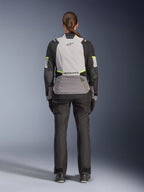 Vrouwelijke motorrijder vanaf de achterkant in de Alpinestars Stella Andes V4 Drystar® Jas, Ice Gray, Dark Gray en zwart met Yellow Fluo accenten, voorzien van een grote opbergzak op de rug en Alpinestars-logo, gecombineerd met een bijpassende zwarte adventure-broek, all-weather motoruitrusting voor touring