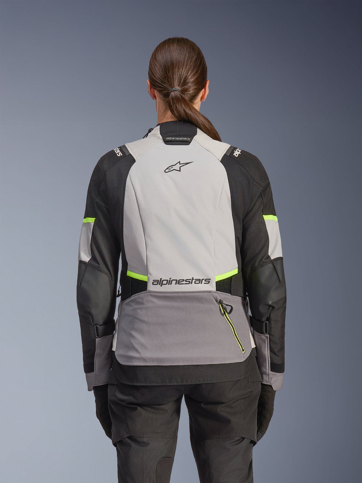Alpinestars Stella Andes V4 Drystar® jas, avontuurlijke motorjas voor dames, achteraanzicht, Ice Gray, Dark Gray en zwart met Yellow Fluo accenten, voorzien van Alpinestars branding op de boven- en onderrug, duurzame textielconstructie voor toerritten in alle weersomstandigheden