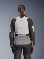 Alpinestars Stella Andes V4 Drystar® jas, avontuurlijke motorjas voor dames, achteraanzicht, Ice Gray, Dark Gray en zwart met Yellow Fluo accenten, voorzien van Alpinestars branding op de boven- en onderrug, duurzame textielconstructie voor toerritten in alle weersomstandigheden
