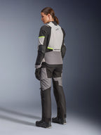 Alpinestars Stella Andes V4 Drystar® damesjas, adventure-touring motorjas, Ice Gray en Dark Gray met Yellow Fluo accenten, achteraanzicht van een model met bijpassende textielbroek, voorzien van een waterdichte constructie en versterkte ripstop-panelen.