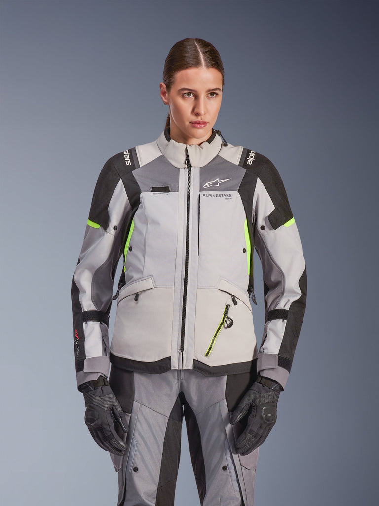 Alpinestars Woman Stella Andes V4 Drystar® Jacket, Ice Gray and Dark Gray with Yellow Fluo accents, adventure touring motorcycle jacket, worn with matching pants and gloves, featuring protective textile construction and Alpinestars branding.