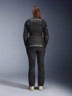Woman wearing Alpinestars Stella Andes Air Drystar® Jacket and matching pants, Black, back view showing large grey alpinestars branding on the lower back pouch, small red star logo on upper back, mesh ventilation panels, and reflective details for adventure touring