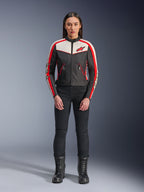 Alpinestars Stella T-Dyno WR Jas, textiele motorjas voor dames, zwart, ecru en felrood, gedragen door model met zwarte broek en laarzen, vintage-geïnspireerd ontwerp met rood Alpinestars logo en contrastpanelen.