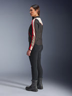 Alpinestars Stella T-Dyno WR Jas, textiele motorjas voor dames, zwart, ecru en helderrood, met een vintage-geïnspireerd ontwerp en Astars-branding op de mouw, gedragen met een slanke zwarte broek en zwarte laarzen, kortere biker-pasvorm voor stadsritten.