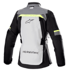 Alpinestars Stella Bogotá Pro Drystar® dames motorjas, achteraanzicht, Ice Gray en Dark Gray met fluorescerend gele accenten, voorzien van een groot logo op de rug, 'Tech Touring' tekst, verticale ventilatieritsen en versterkte accordeonpanelen op de ellebogen.
