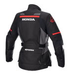 Alpinestars Stella Honda Andes V3 Drystar® damesjas, adventure motorjas, zwart, tar gray en felrood, achteraanzicht met groot wit HONDA-logo en rode Alpinestars-graphics, waterdichte textielconstructie met verstelbare taille en handige zakken