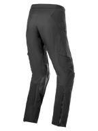 Alpinestars AMT-8 Stretch Drystar® XF broek, adventure touring motorbroek, zwart, driekwart achteraanzicht met accordeon stretchpanelen op de kuiten, geitenleren verstevigingen aan de binnenzijde van de knie en ritssluiting aan de broekspijp.