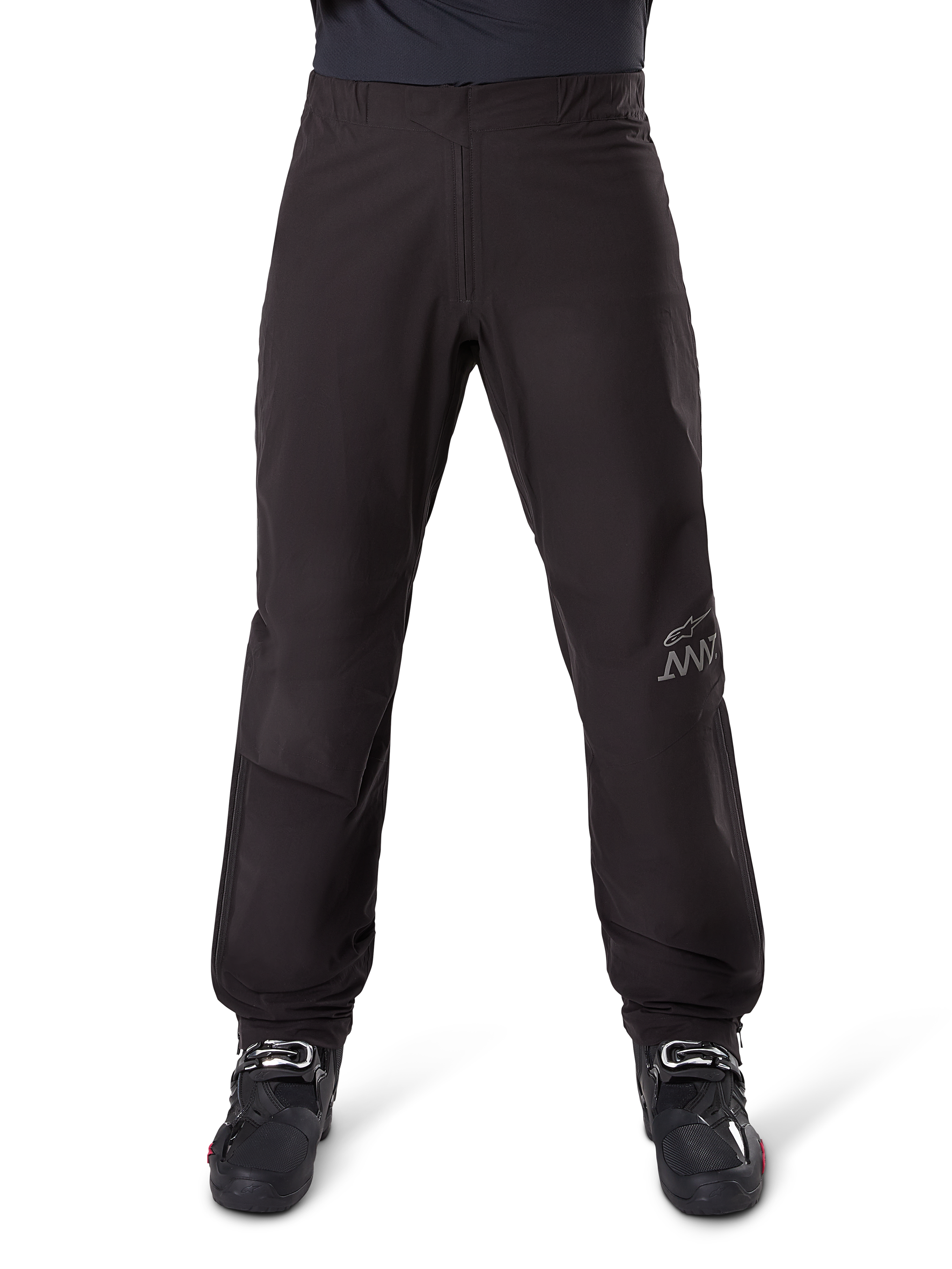 Alpinestars AMT-8 Stretch Drystar® XF voering, zwart, vooraanzicht gedragen met zwarte motorlaarzen, grijs sterlogo en AMT-branding op de broekspijp, veelzijdige waterdichte en winddichte motorkleding.