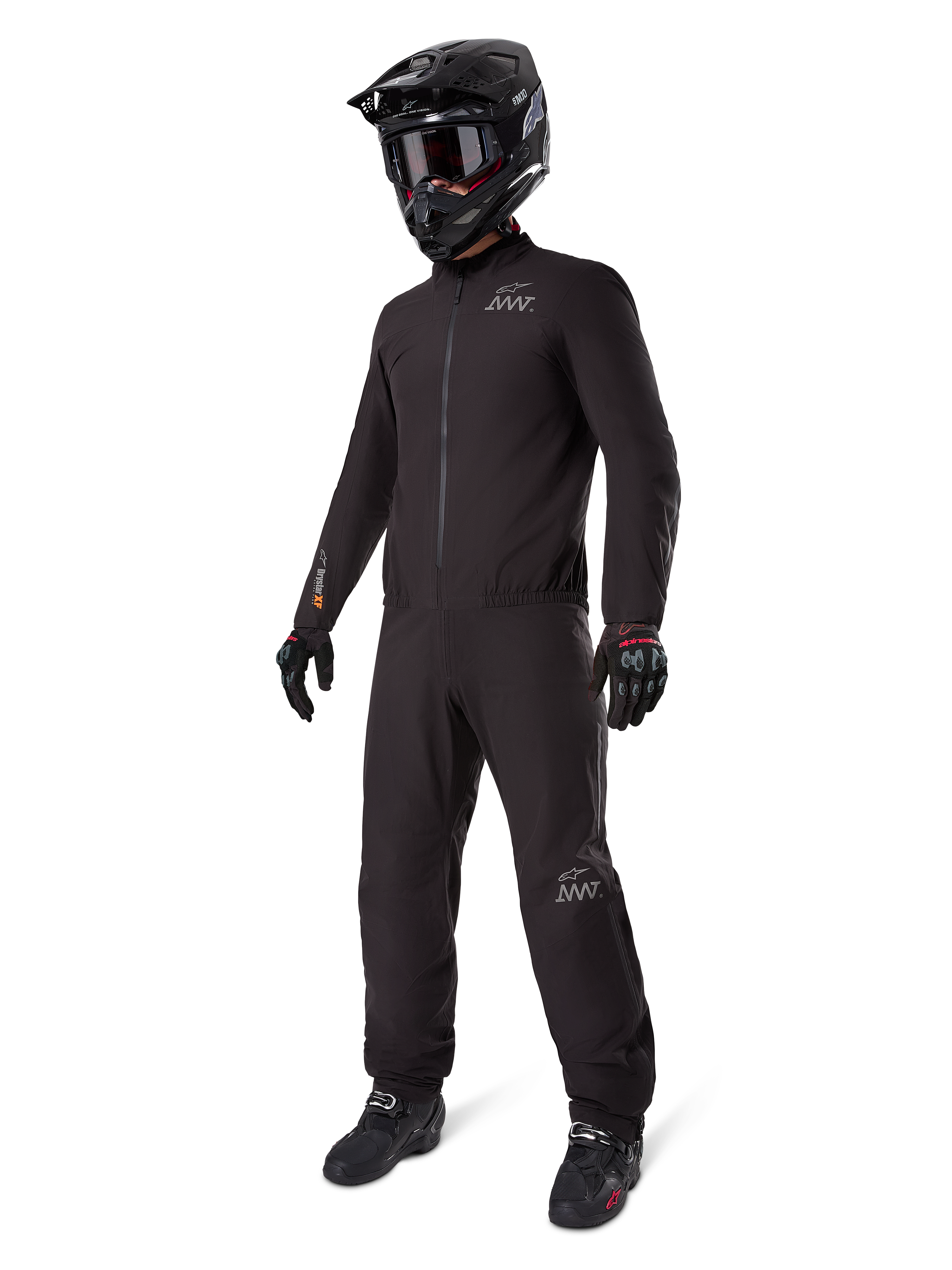 Alpinestars AMT-8 Stretch Drystar XF Liner, volledig zwart adventure touring pak, water- en winddichte jas en broek, gecombineerd met een zwarte adventure helm, motorbril, handschoenen en motorlaarzen, voorzien van AMT-logo's en Drystar XF-branding op de mouwen en pijpen.