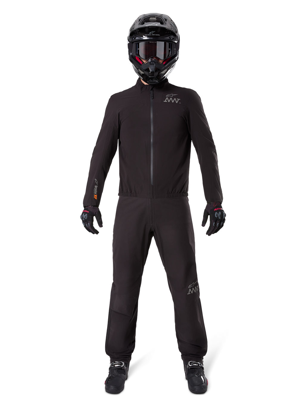 Motorrijder in Alpinestars AMT-8 Stretch Drystar® XF broekvoering en bijpassende jas, volledig zwarte waterdichte en winddichte technische uitrusting, met een zwarte helm, handschoenen en laarzen, strak adventure touring ontwerp.