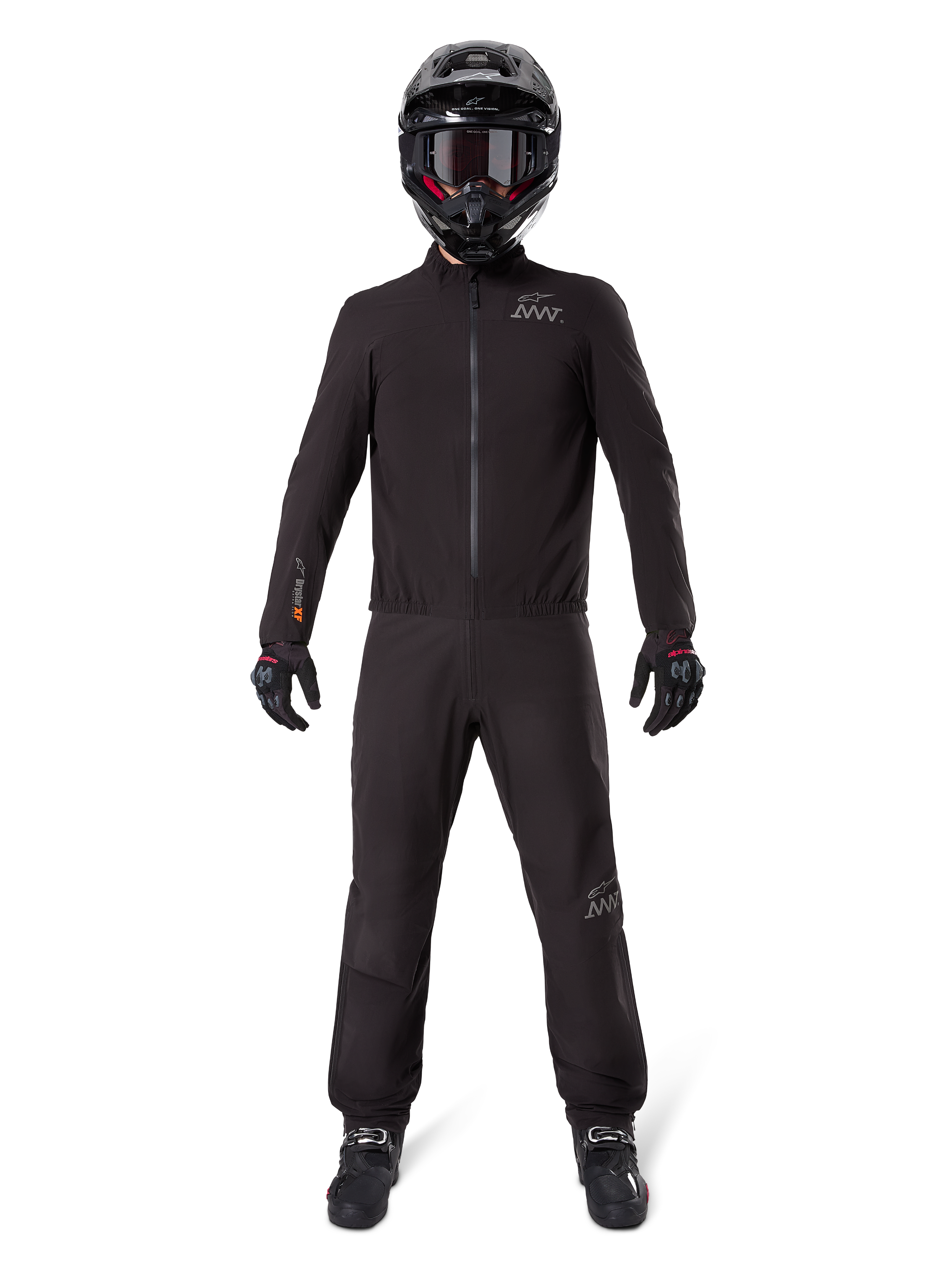 Motorrijder in Alpinestars AMT-8 Stretch Drystar® XF broekvoering en bijpassende jas, volledig zwarte waterdichte en winddichte technische uitrusting, met een zwarte helm, handschoenen en laarzen, strak adventure touring ontwerp.