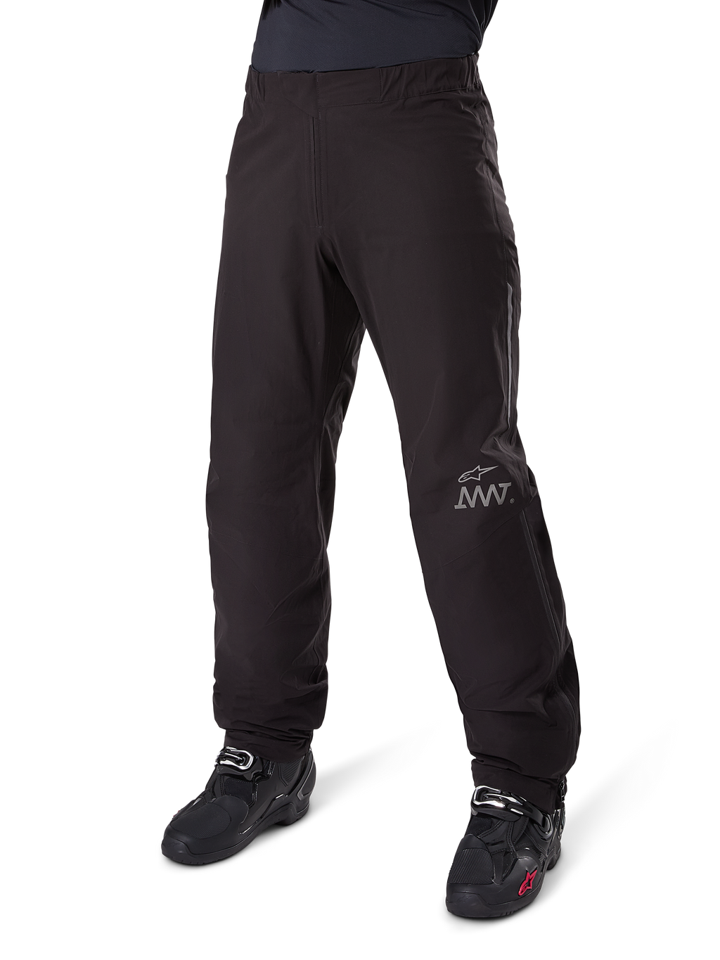 Alpinestars Amt-8 Stretch Drystar® XF binnenbroek, zwart, waterdichte en rekbare textielconstructie met zilverkleurig AMT-logo, gedragen met zwarte motorlaarzen, onderdeel van adventure touring motoruitrusting.