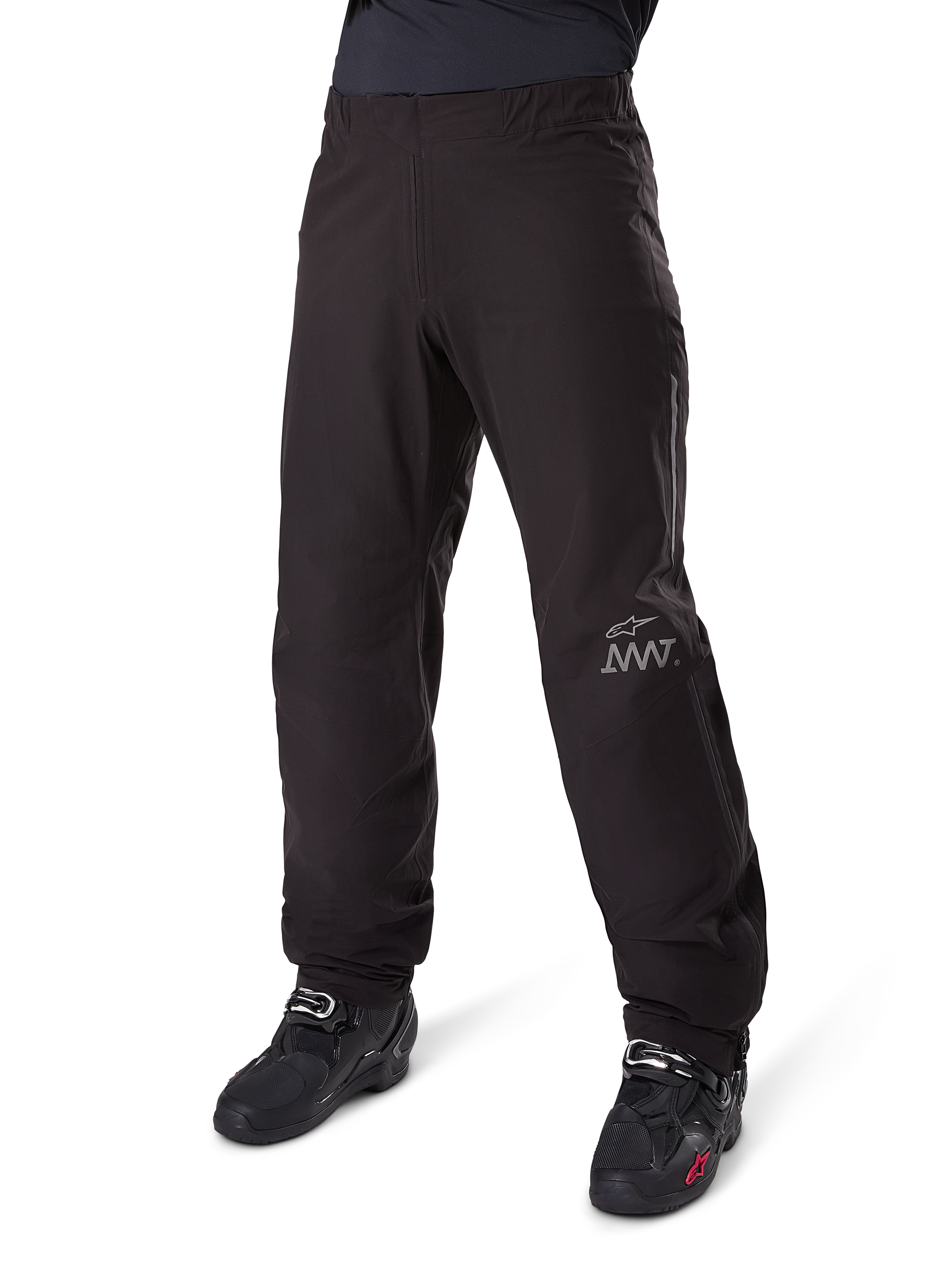 Alpinestars Amt-8 Stretch Drystar® XF binnenbroek, zwart, waterdichte en rekbare textielconstructie met zilverkleurig AMT-logo, gedragen met zwarte motorlaarzen, onderdeel van adventure touring motoruitrusting.