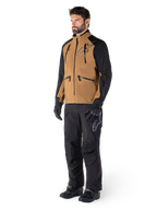 Alpinestars Hyde XT Drystar® broek, adventure motorbroek, zwart, gedragen met een bruine en zwarte technische jas, zwarte handschoenen en laarzen, met een over-de-laars ontwerp voor off-road en dual-sport rijden