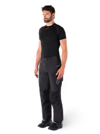 Alpinestars Hyde XT Drystar® broek, zwarte adventure touring motorbroek gedragen door een model met een zwart compressieshirt en zwarte laarzen, voorzien van een technische waterdichte constructie en Drystar®XF-branding.