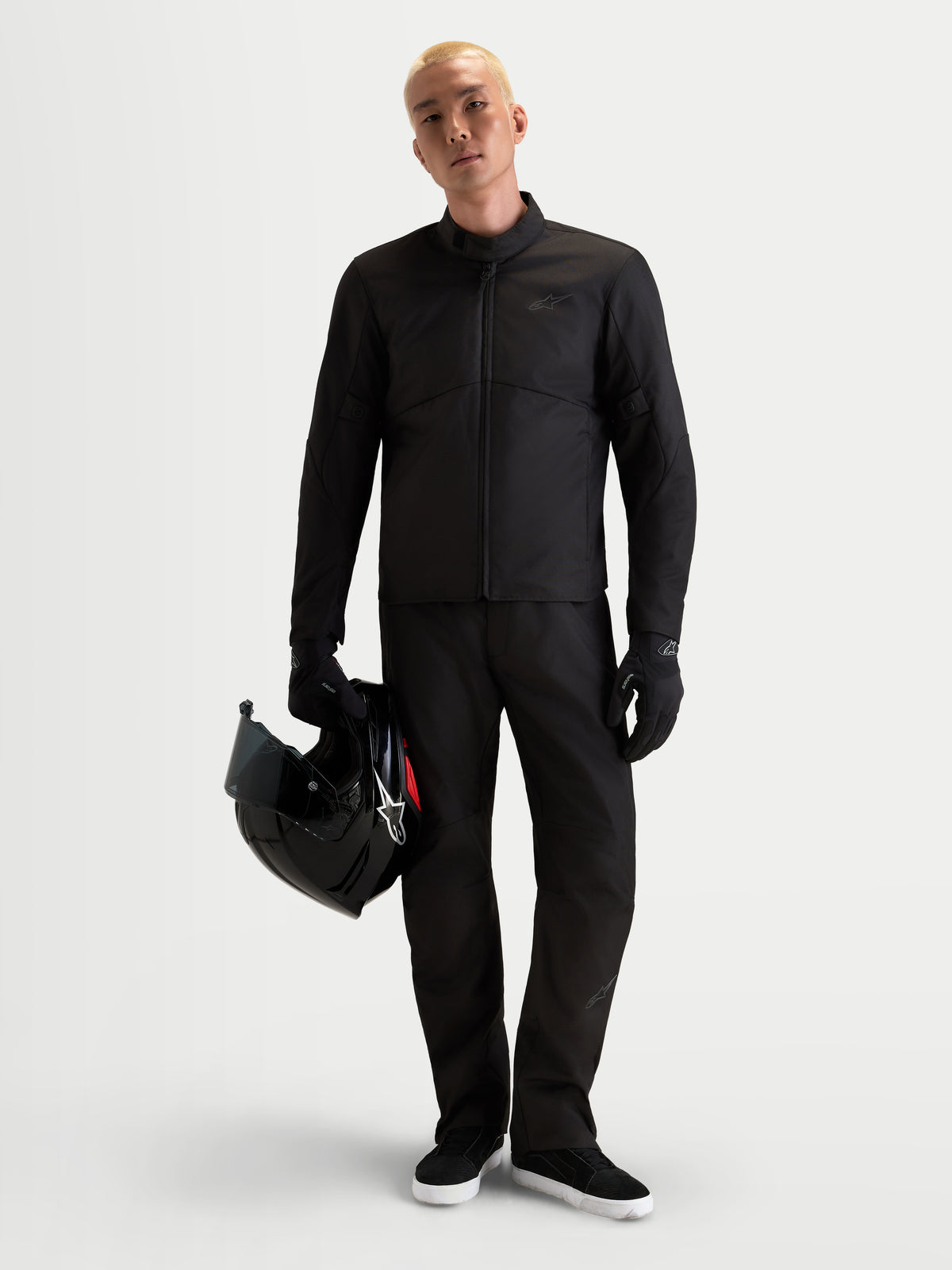 Alpinestars C 1 Waterproof broek, urban motorbroek voor heren in zwart, rechte pasvorm winter-motoruitrusting met CE-gecertificeerde bescherming, gedragen door een model dat een helm vasthoudt