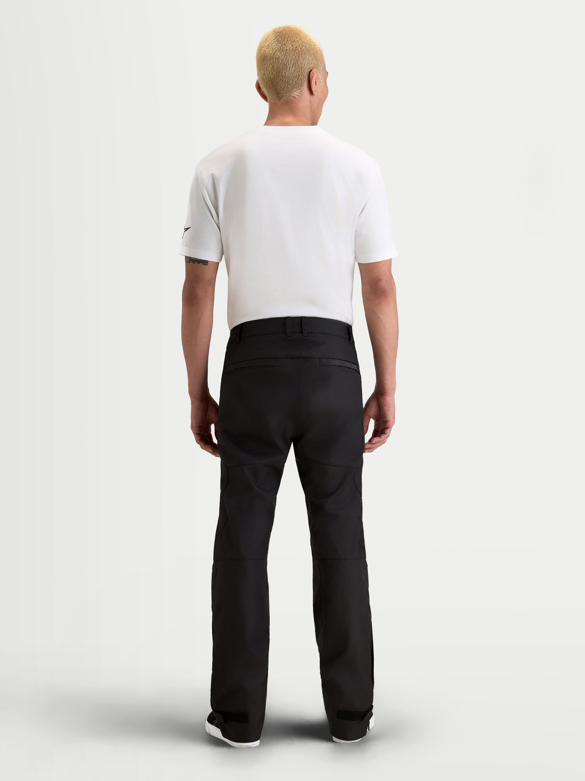 Alpinestars C-1 Waterproof broek, urban motorbroek voor heren in zwart, achteraanzicht op model met witte t-shirt en waterdichte textieluitrusting