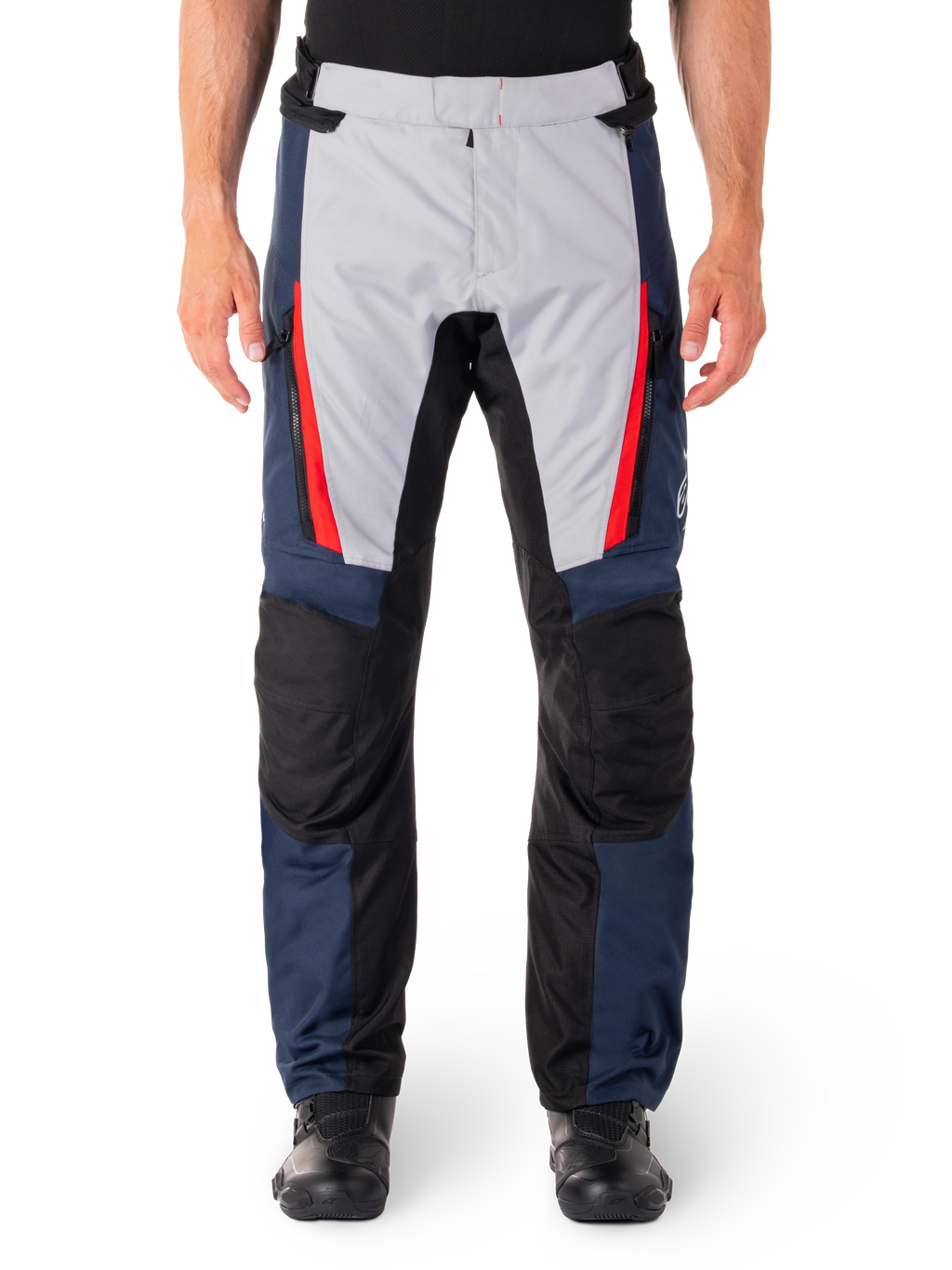 Alpinestars ST-1 waterdichte broek, motortoerbroek, donkerblauw en lichtgrijs met felrode accenten, zwarte versterkte kniepanelen, vooraanzicht gedragen met zwarte laarzen, waterdichte adventure touring uitrusting