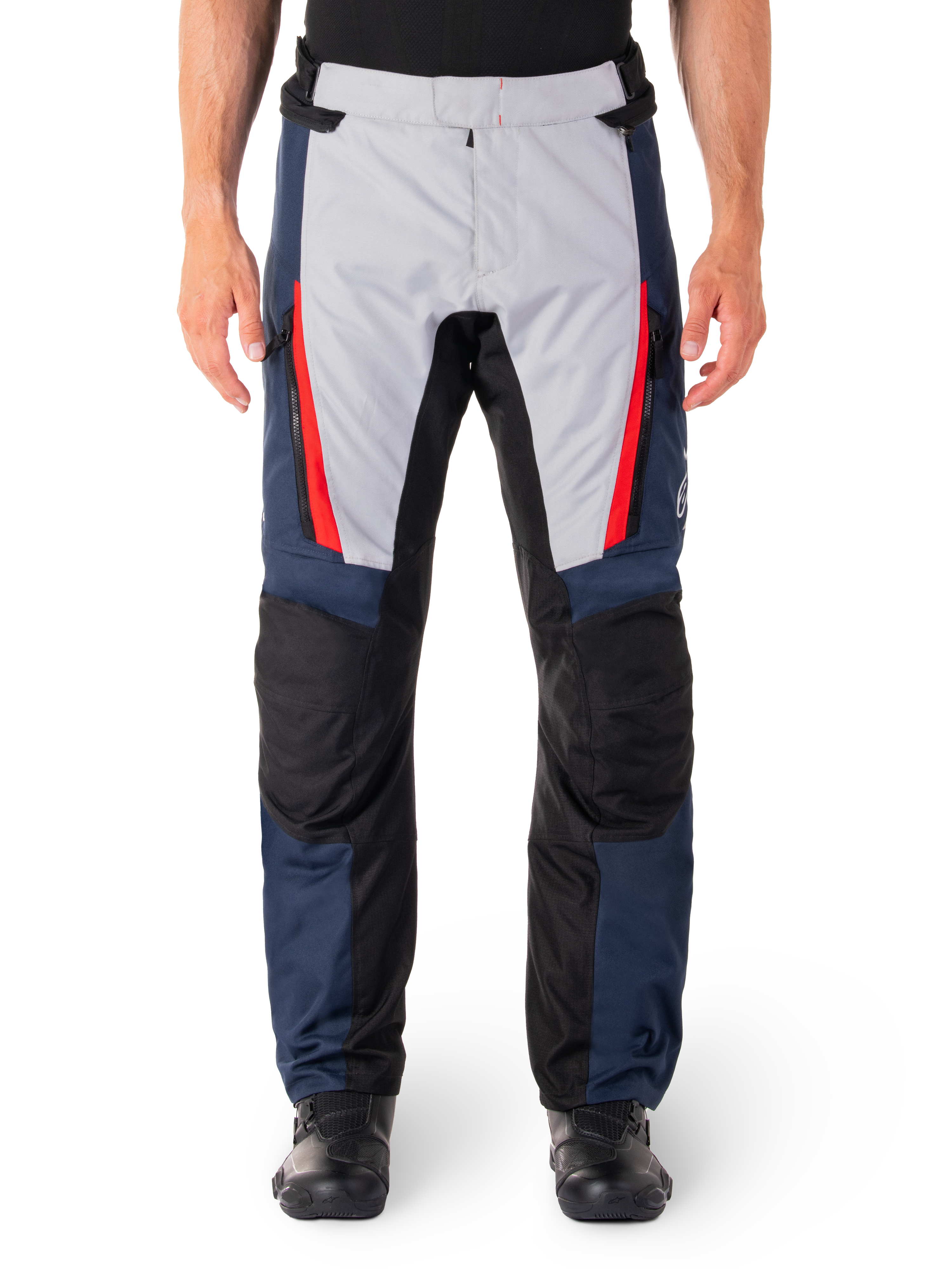 Alpinestars ST-1 waterdichte broek, motortoerbroek, donkerblauw en lichtgrijs met felrode accenten, zwarte versterkte kniepanelen, vooraanzicht gedragen met zwarte laarzen, waterdichte adventure touring uitrusting
