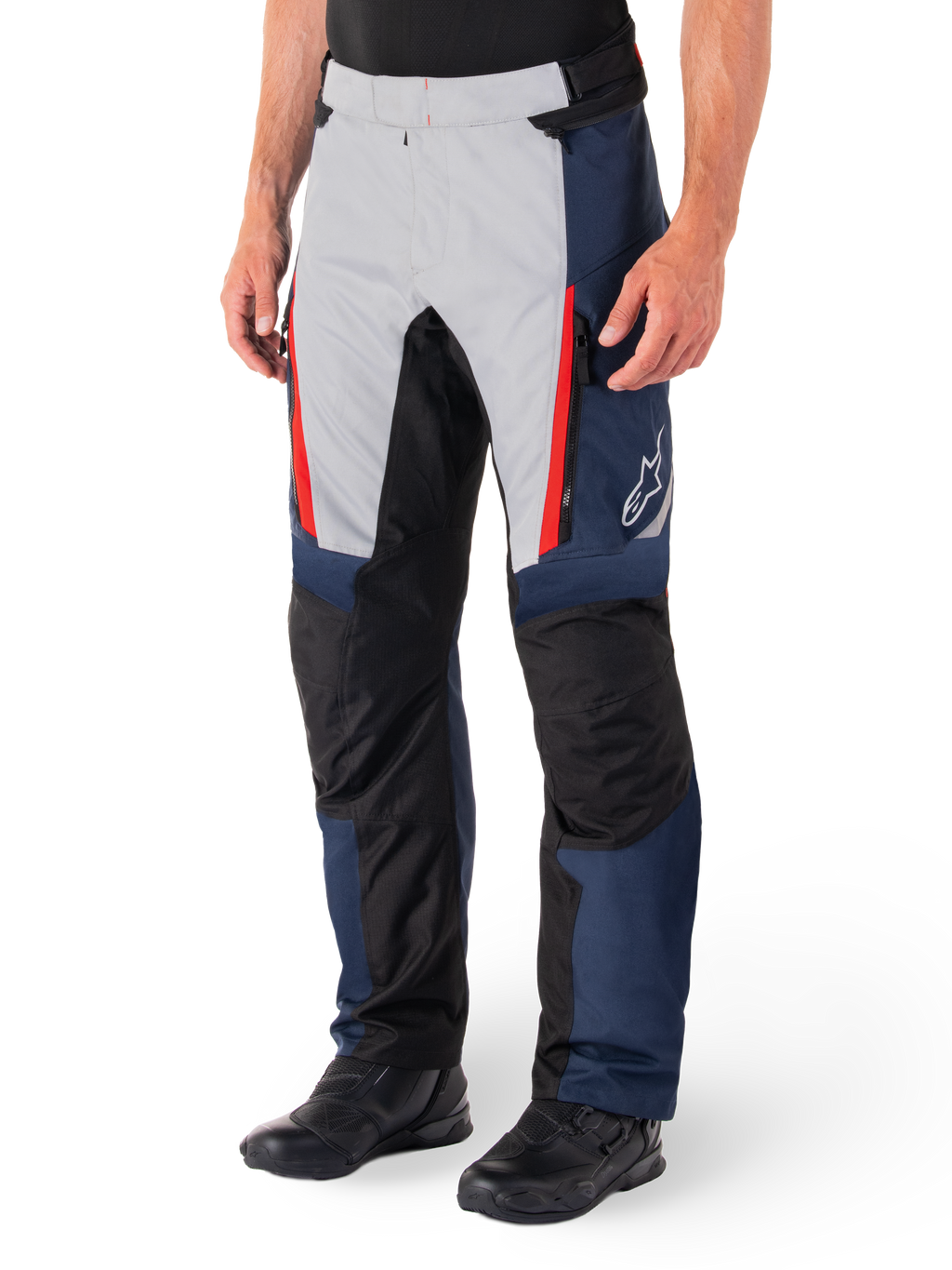 Alpinestars St-1 Waterproof Broek, motor tourbroek, donkerblauw, zwart en helderrood, voorzien van lichtgrijze voorpanelen met rode ritsaccenten, zwarte verstevigde kniestukken en een wit Alpinestars-logo op de zijkant, gedragen met zwarte motorlaarzen.
