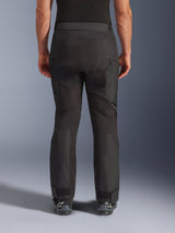 Alpinestars Cusco Drystar® broek, motorbroek, zwart, achteraanzicht gedragen door een rijder, voorzien van getextureerde textielpanelen, ventilatieopeningen met rits op de dijen en verstelbare enkelsluitingen, gecombineerd met zwarte Alpinestars laarzen