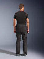 Rijder draagt Alpinestars Cusco Drystar® broek, zwarte adventure motorbroek, achteraanzicht, gecombineerd met een zwart compressieshirt met korte mouwen en zwarte motorlaarzen, voorzien van een duurzaam textielontwerp met voorgevormde panelen voor touring