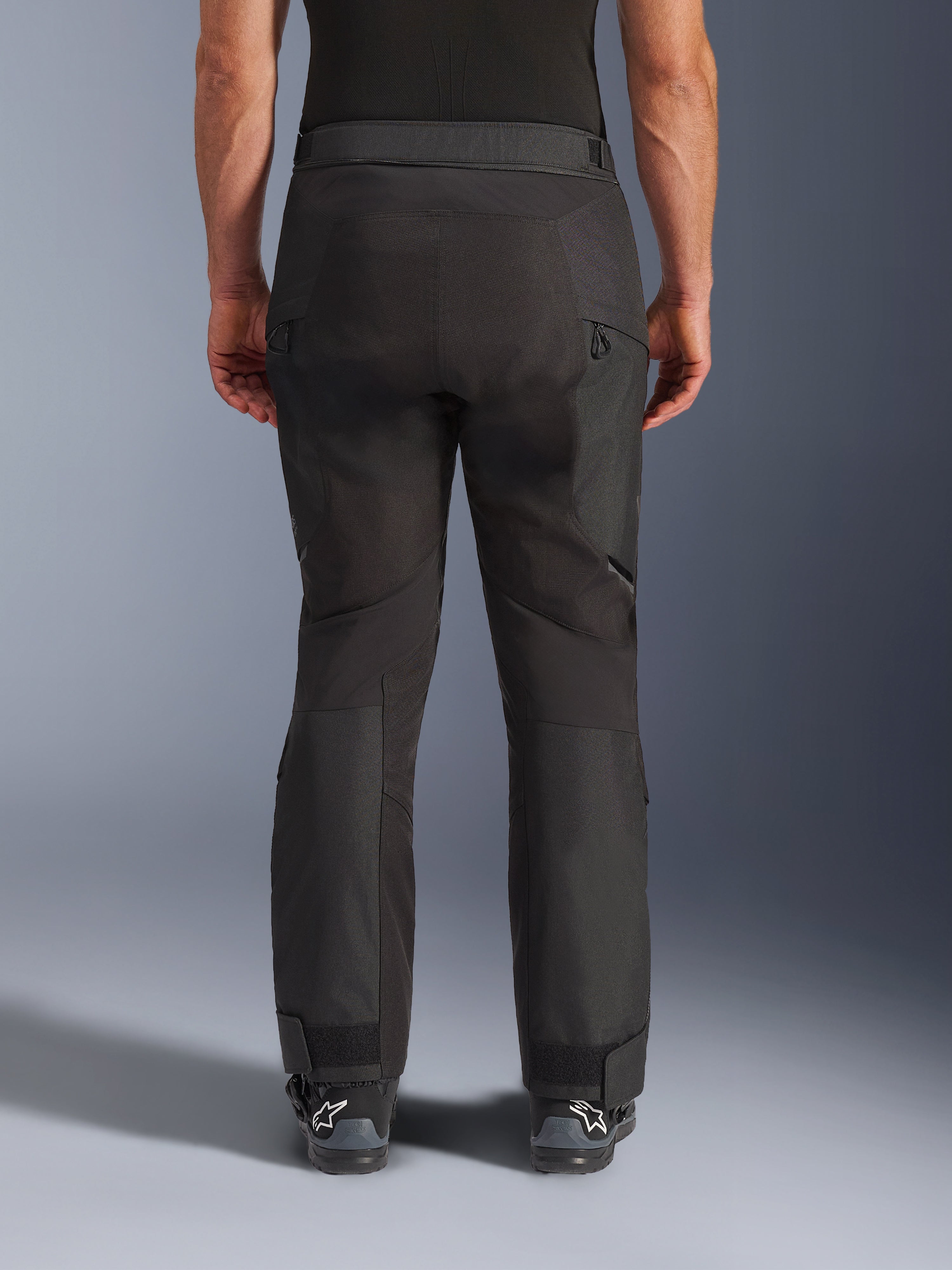 Alpinestars Cusco Drystar® broek, adventure motorbroek, zwart, achteraanzicht met voorgevormde panelen, ventilatieopeningen met rits op de dijen en verstelbare enkelmanchetten, ontworpen voor touring en off-road rijden