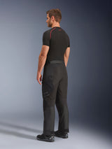 Alpinestars Cusco Drystar® broek, adventure motorbroek, zwart, zij- en achteraanzicht van model, gecombineerd met een zwarte basislaag en zwarte motorlaarzen, technische textielconstructie met ritszakken en voorgevormde knieën
