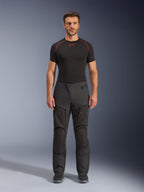 Alpinestars Cusco Drystar® broek, textiel motorbroek, zwart, gedragen door een model met een zwarte basislaag en laarzen, adventure touring-ontwerp met ritsbare ventilatiepanelen op de dijen en duurzame multi-panel constructie