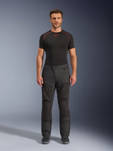 Alpinestars Cusco Drystar® broek, textiel motorbroek, zwart, gedragen door een model met een zwarte basislaag en laarzen, adventure touring-ontwerp met ritsbare ventilatiepanelen op de dijen en duurzame multi-panel constructie