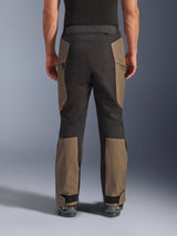 Alpinestars Cusco Drystar® broek, adventure motorbroek, Walnut Black, achteraanzicht op model, duurzame textielconstructie met kleurgeblokte panelen, verstelbare zoom en detail met rits in de taille voor touring en adventure rijden