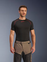 Alpinestars Cusco Drystar® broek, Walnut Black adventure motorbroek, gedragen door een model met een zwart Alpinestars base layer shirt, voorzien van een tweekleurig bruin en zwart textielontwerp met verstevigde panelen voor touring.