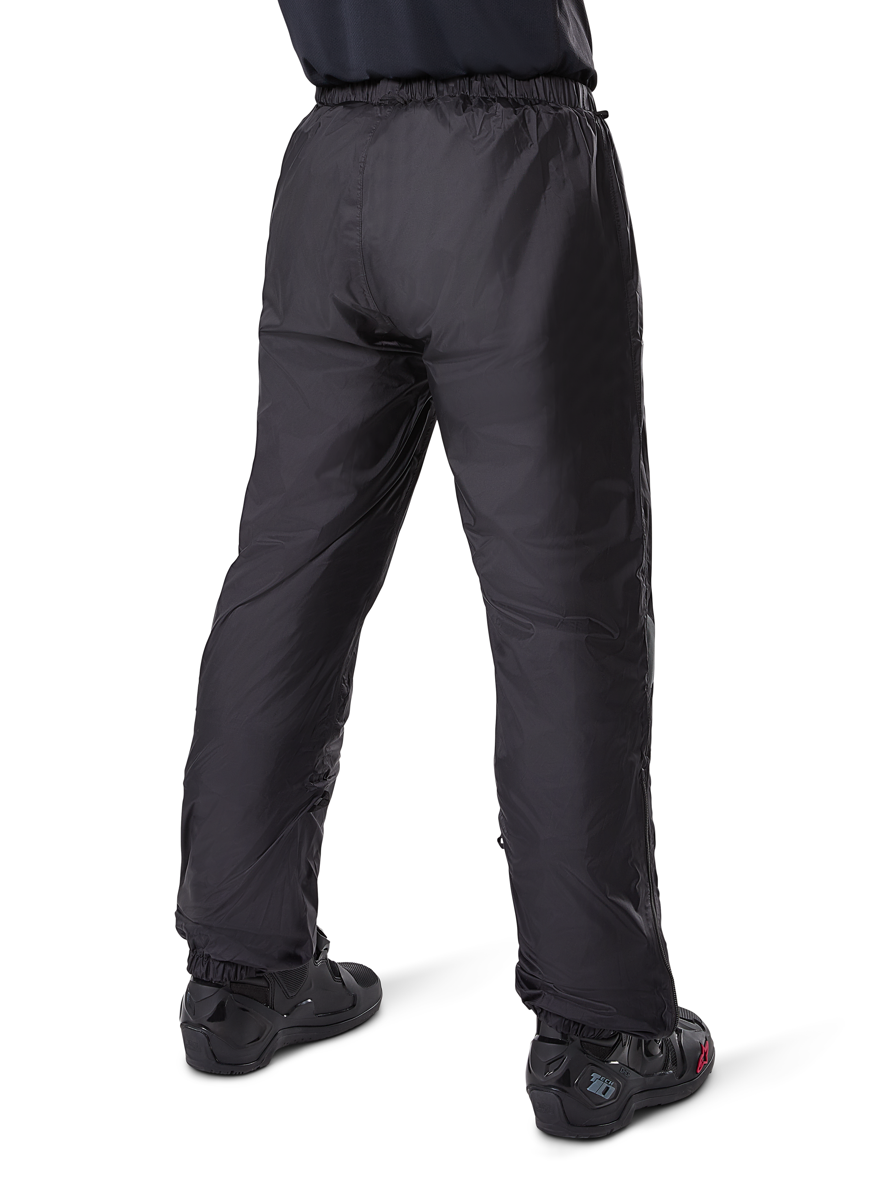 Alpinestars Bogota' Pro Drystar® 3 Seizoenen Broek, zwarte adventure touring motorbroek, achteraanzicht van de waterdichte Drystar®-voering gedragen als overbroek, gecombineerd met zwarte motorlaarzen, technische lichtgewicht constructie voor weersbescherming in meerdere seizoenen