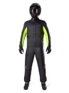 Alpinestars Bogota Pro Drystar 3-seizoenenbroek, zwart, gedragen door een motorrijder in een volledige adventure-outfit inclusief een zwart en neongeel waterdicht jack, zwarte helm en motorlaarzen, ontworpen voor toerprestaties in alle weersomstandigheden.